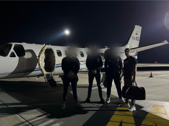 Daniel with friends in front of a private jet at night