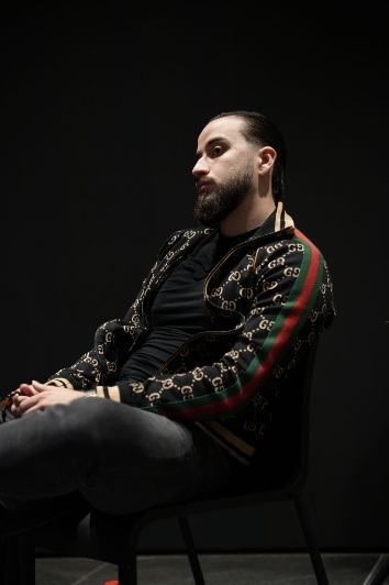 Daniel sitting in a chair in dark lighting